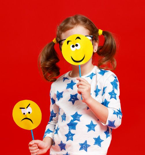 Trauriges Kind hält sich die Hände vor das Gesicht